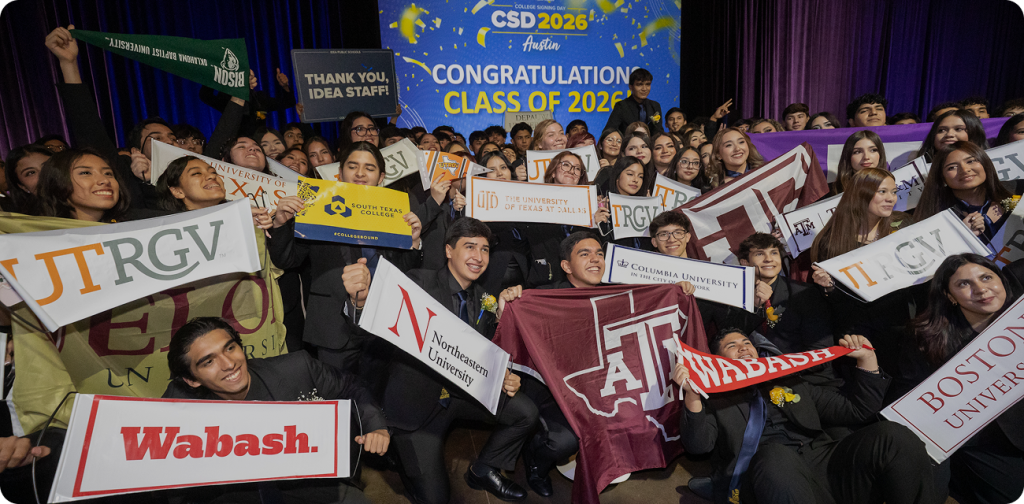 Students celebrating College Signing Day with university signs.